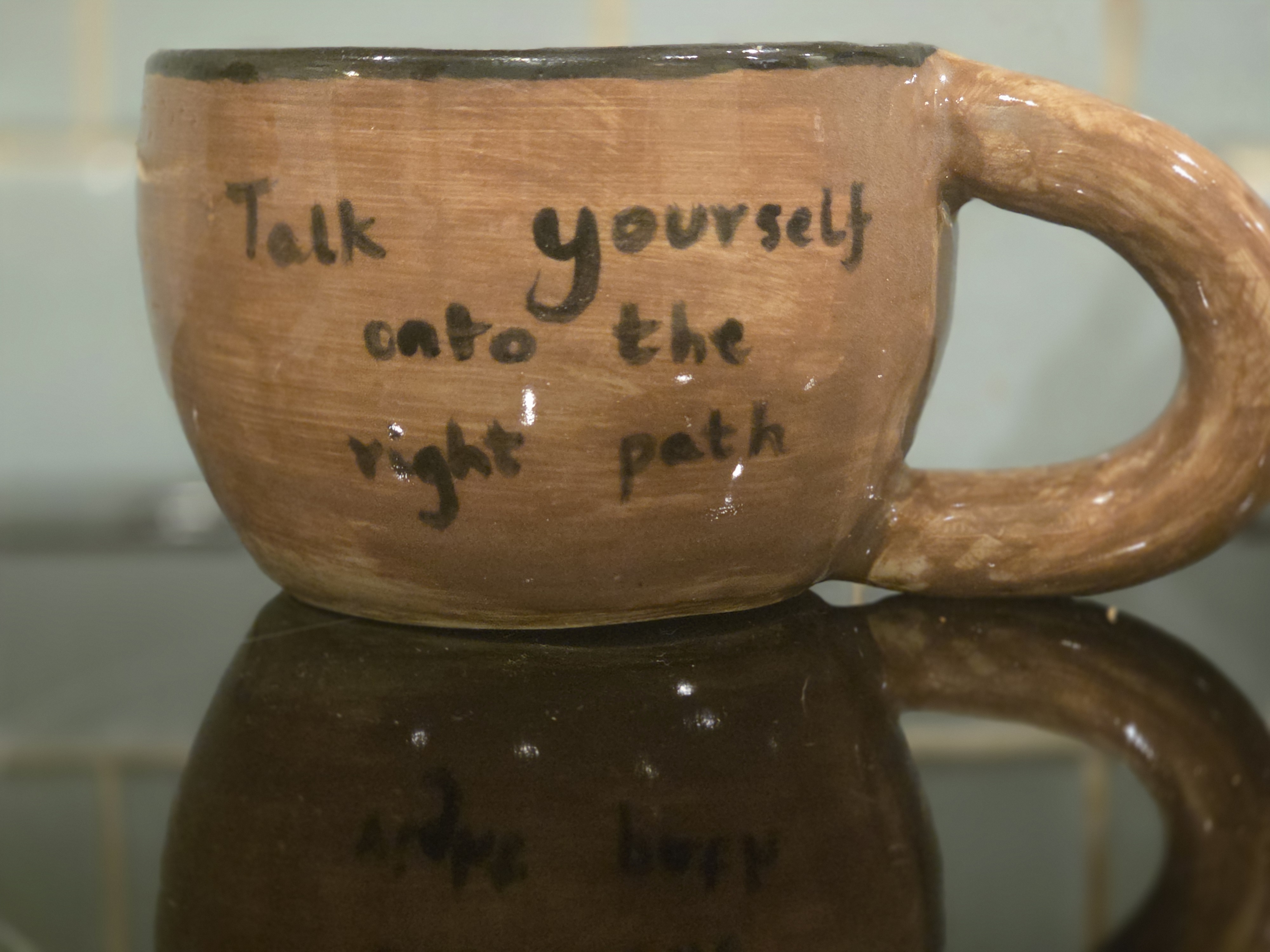 Brown mug with talk yourself onto the right path written on it in black